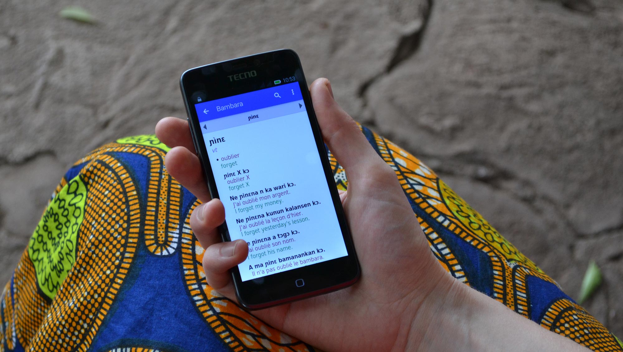 Una mujer usando el diccionario bambara en su teléfono móvil